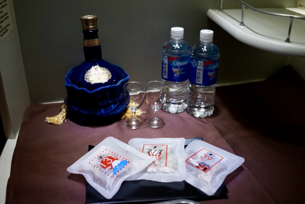 JAL国際線ファーストクラス機内食：バーカウンターに置かれた飲料とスナック